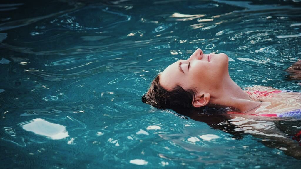 Mulher flutuando em uma piscina