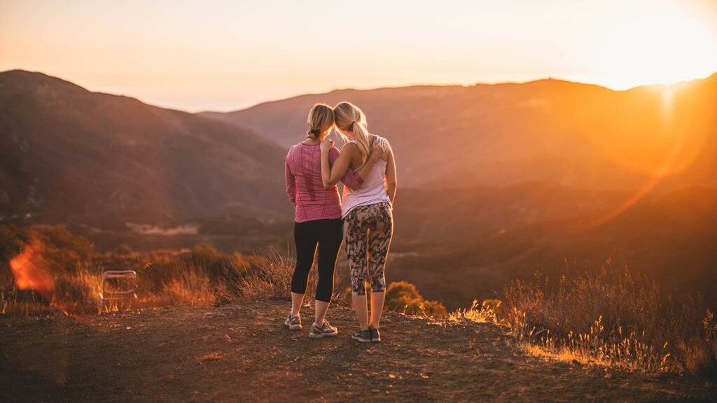Mulheres vendo o sol depois de fazerem uma trilha