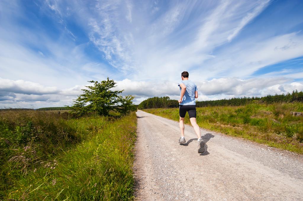 homem correndo em estrada de terra no campo