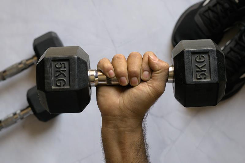mão segurando halter de 5kg
