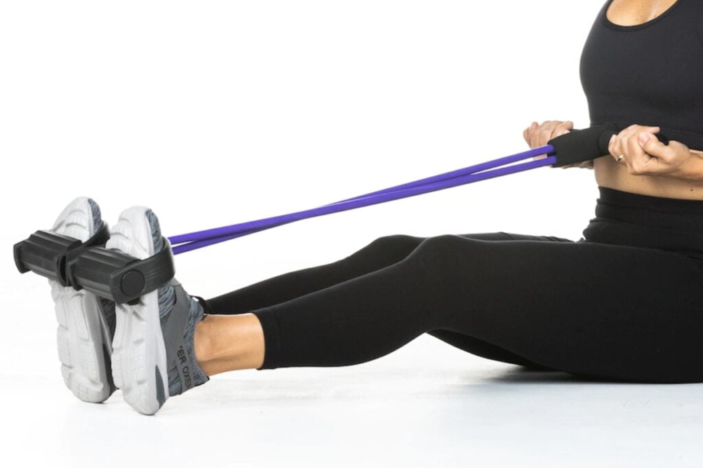 mulher usando elástico extensor para as pernas