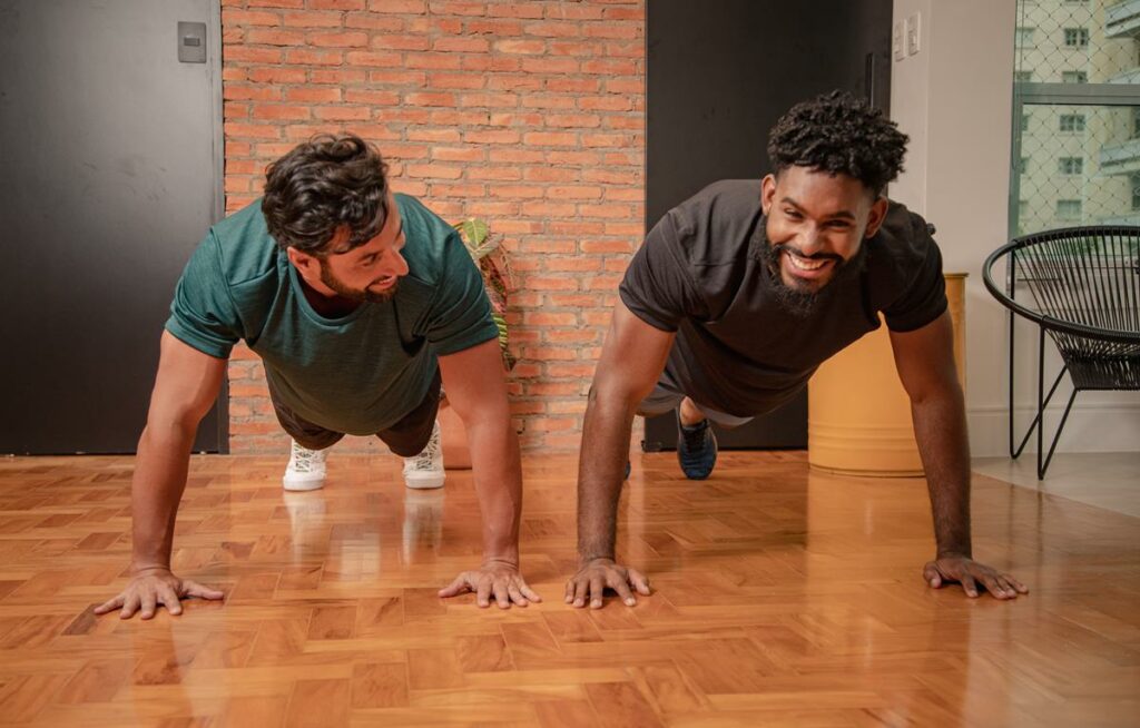 dois homens fazendo exercício de prancha em casa