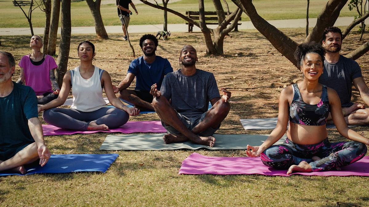 Foto de um grupo de pessoas fazendo yoga e meditação ao ar livre. Técnica 478