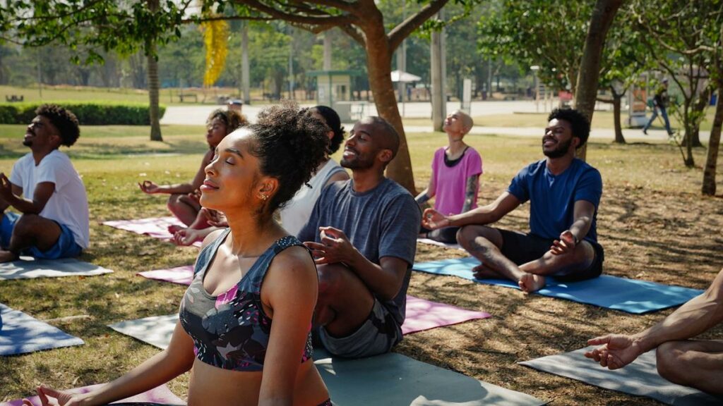 Foto de um grupo de pessoas praticando yoga no parque