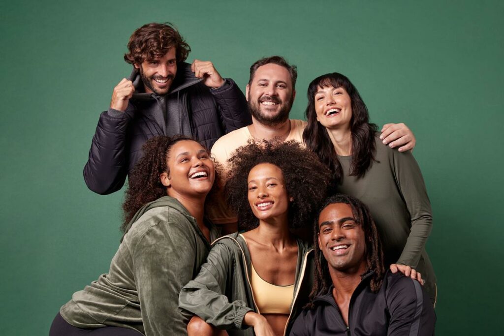 seis pessoas usando vestuário da coleção de inverno 2023 da Oxer Brasil em fundo verde