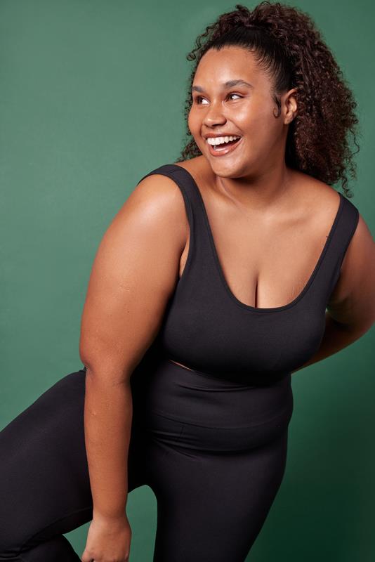 mulher usando vestuário da coleção de inverno 2023 da Oxer Brasil em fundo verde