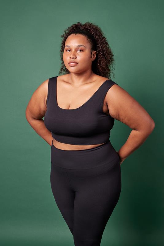 mulher usando vestuário da coleção de inverno 2023 da Oxer Brasil em fundo verde