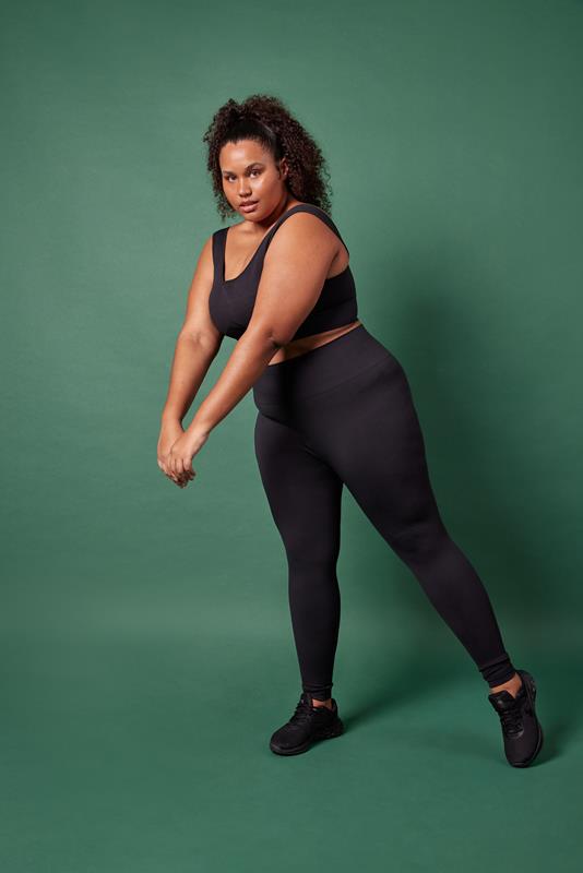 mulher usando vestuário da coleção de inverno 2023 da Oxer Brasil em fundo verde