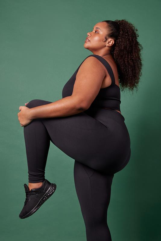 mulher usando vestuário da coleção de inverno 2023 da Oxer Brasil em fundo verde