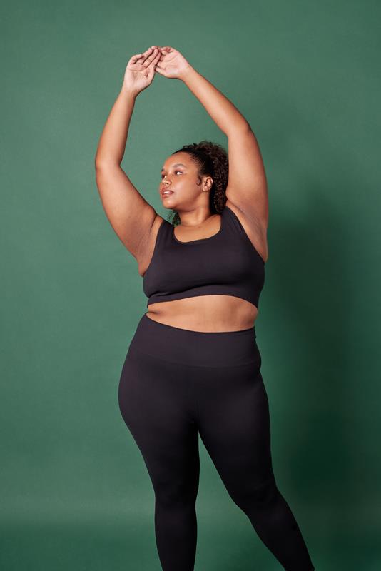 mulher usando vestuário da coleção de inverno 2023 da Oxer Brasil em fundo verde