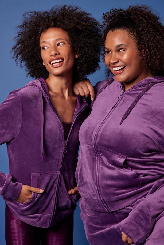 duas mulheres usando vestuário da coleção de inverno 2023 da Oxer Brasil em fundo azul