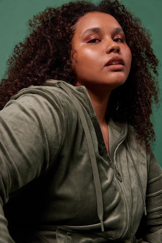 mulher usando vestuário da coleção de inverno 2023 da Oxer Brasil em fundo verde