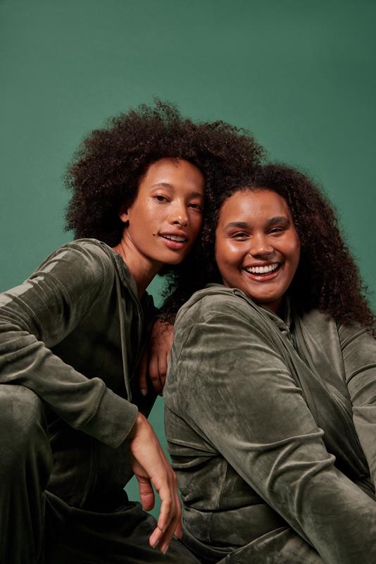duas mulheres usando vestuário da coleção de inverno 2023 da Oxer Brasil em fundo verde