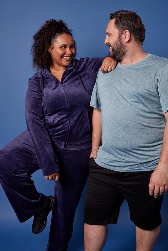 duas pessoas usando vestuário da coleção de inverno 2023 da Oxer Brasil em fundo azul